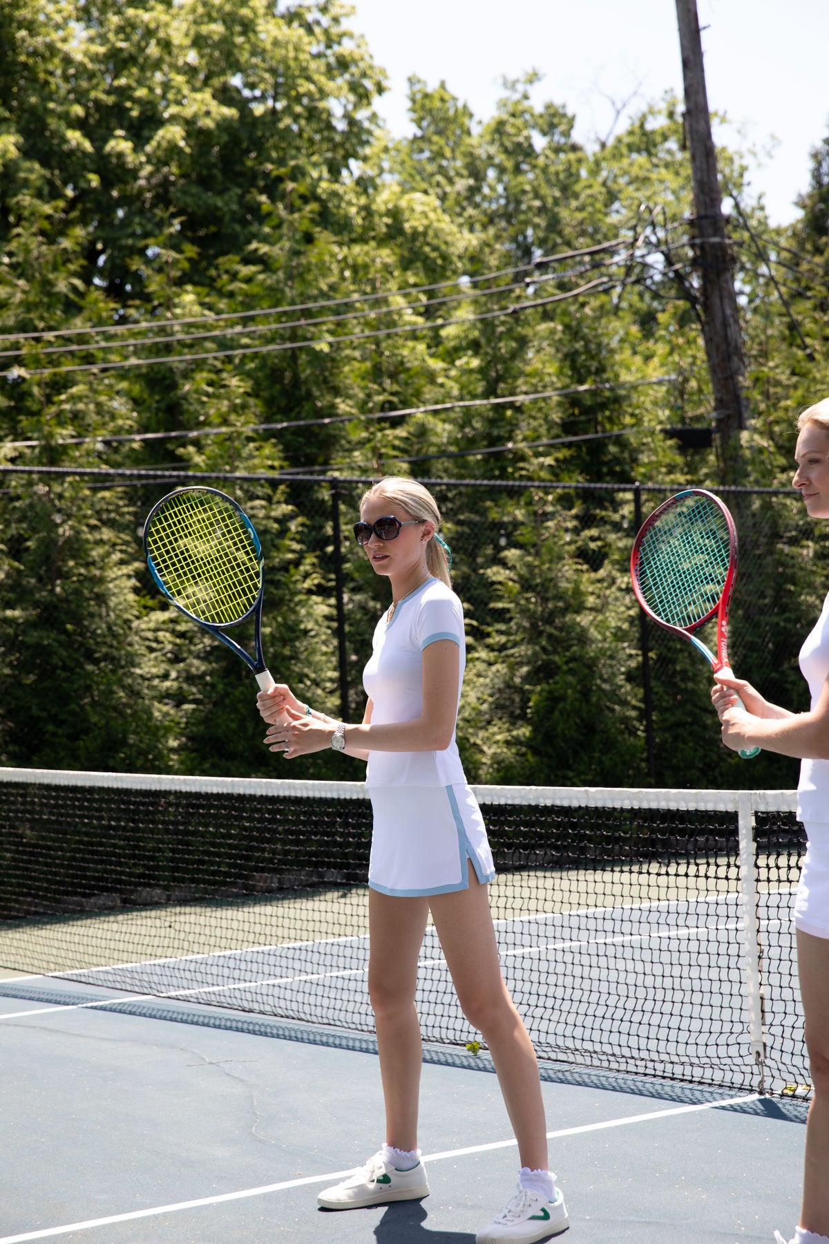 Club & Court Stacy Tee and Stacy Skort at the net with a tennis racquet